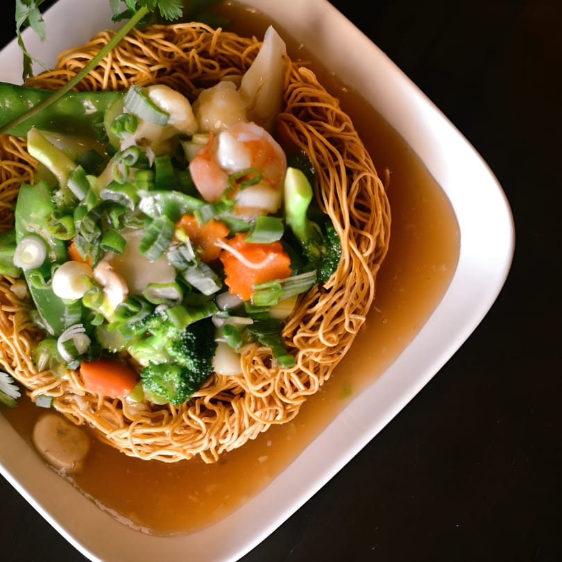 Crispy Asian noodles with shrimp, broccoli, carrots, and snow peas in a savory sauce.